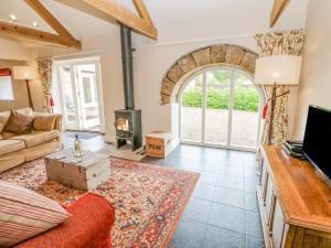 a living room with a couch and a fireplace at Gallow Law Cottage in Greenhaugh