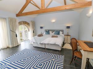 a bedroom with a bed and a desk and a table and chair at Gallow Law Cottage in Greenhaugh