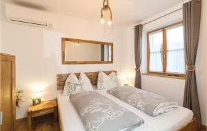 a bedroom with a bed with a mirror and a window at Schönes Ferienhaus Eisenberg in Eisenberg an der Pinka