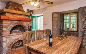 einen Holztisch mit Weingläsern und einen Steinkamin in der Unterkunft Stunning Home In Punat With Kitchen in Stara Baška