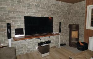 uma televisão de ecrã plano numa parede de tijolos em Gorgeous Home In Hovden With House A Mountain View em Hovden