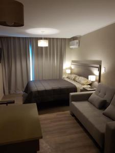 Habitación de hotel con cama y sofá en Apart 312 Casa de Playa en Necochea