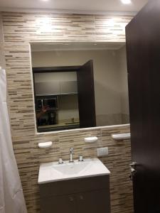 La salle de bains est pourvue d'un lavabo et d'un miroir. dans l'établissement Apart 312 Casa de Playa, à Necochea
