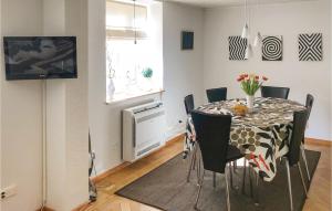 a dining room with a table with chairs and a television at Awesome Home In Ystad With 1 Bedrooms And Wifi in Ystad