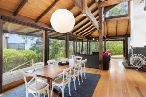 a dining room with a wooden table and chairs at Dridan House in Lorne