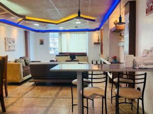 Habitación con bar con sillas y sofá en Confort HOME B Apartamento Claveles, en Baños