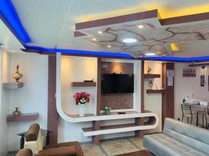sala de estar con sofá y TV en el techo en Confort HOME B Apartamento Claveles, en Baños