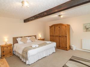 a bedroom with a large bed and a wooden cabinet at The Granary in Sanquhar