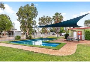 a swimming pool in a yard with a canopy over it at Discovery Parks - Mt Isa in Mount Isa