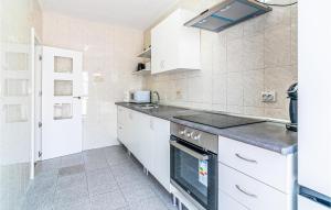 a kitchen with white cabinets and a stove top oven at Gorgeous Apartment In Cordoba With Wifi in Córdoba +13 photos