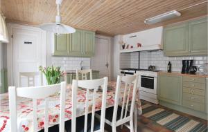 eine Küche mit grünen Schränken und einem Tisch mit Stühlen in der Unterkunft Stunning Home In Virserum With Kitchen in Bockasjögle