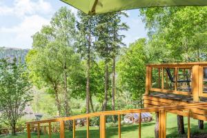 una terraza de madera con vistas a los árboles en Bluebell Cottage, en Llanrwst