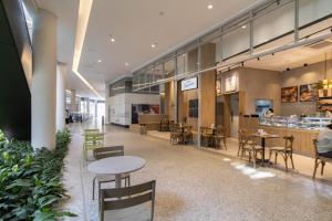 a cafeteria with tables and chairs and a restaurant at Urban Sky Studio - GRU 2204 in Guarulhos