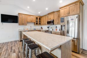 a kitchen with wooden cabinets and a large island with bar stools at Chinook Suite in Garibaldi