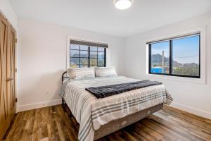 a white bedroom with a bed and a window at Chinook Suite in Garibaldi