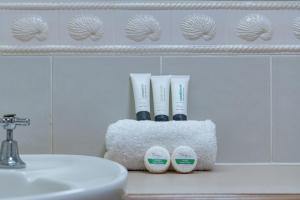 a bathroom with a sink and two electric toothbrushes at Magnificence At Airlie in Airlie Beach