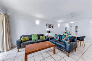 a living room with a couch and a table at Magnificence At Airlie in Airlie Beach