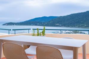 a white table and chairs with a view of the water at Magnificence At Airlie in Airlie Beach