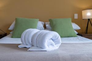 a towel animal sitting on top of a bed at Magnificence At Airlie in Airlie Beach