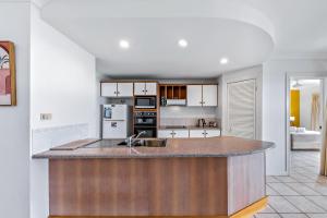 a kitchen with a large island in the middle at Magnificence At Airlie in Airlie Beach