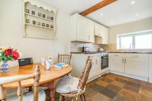 a kitchen with a wooden table and chairs and a table at Bumble Cottage in Darley