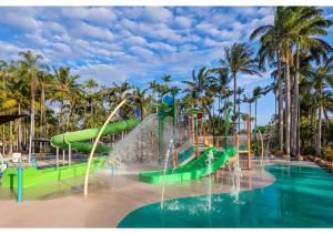 um escorrega aquático num parque aquático com palmeiras em Discovery Parks - Rockhampton em Rockhampton