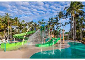 eine Wasserrutsche in einem Wasserpark mit Palmen in der Unterkunft Discovery Parks - Rockhampton in Rockhampton