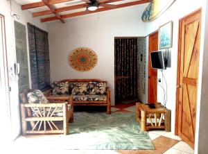 a living room with a couch and a tv at Domi cabin in Dominical