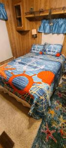 a bed with a colorful comforter on it in a bedroom at Model Home near Camp Lejeune with Water View in Sneads Ferry