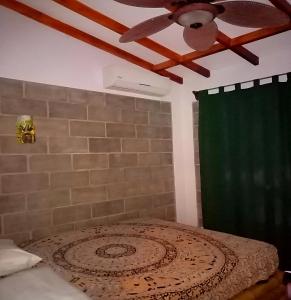 1 dormitorio con 1 cama y ventilador de techo en Domi cabin, en Dominical