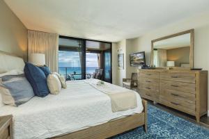 a bedroom with a large bed and a large mirror at Mahana 316 in Kaanapali