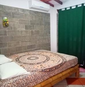 Łóżko w pokoju z zieloną zasłoną prysznicową w obiekcie Domi cabin w mieście Dominical