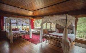 a bedroom with two beds and a canopy bed at Quiet Mind Lodge, Spa & Retreat Sequoias in Kernville