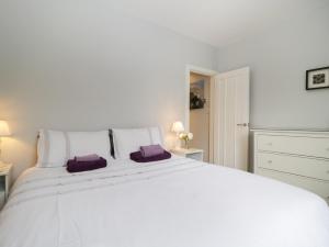 ケズウィックにあるBanks Placeの白いベッドルーム(紫色の枕を使用した大きな白いベッド付)