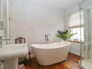 a bathroom with a white tub and a sink at Banks Place in Keswick +5 photos