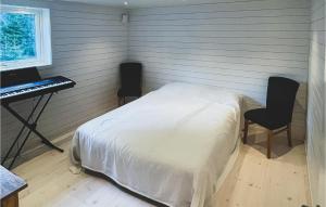 Kåröd的住宿－2 Bedroom Gorgeous Home In Stillingsn，一间卧室配有一张床、一张书桌和一个键盘