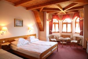 a bedroom with a bed and a table and chairs at Hajdú Kastély Hotel in Hajdúszoboszló