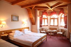 1 dormitorio con 1 cama, mesa y sillas en Hajdú Kastély Hotel, en Hajdúszoboszló