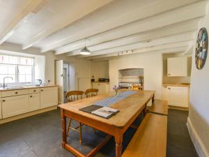 a kitchen with a wooden table in a room at Tregonhawke Farmhouse in Cawsand