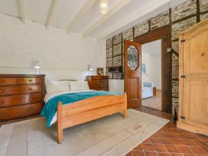 a bedroom with a bed and a dresser and a door at Tregonhawke Farmhouse in Cawsand