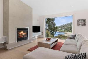 a living room with a fireplace and a large window at Drift - Luxury, location and ocean views in Wye River