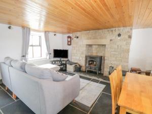 a living room with a couch and a fireplace at Mary Kate's Cottage in Narin