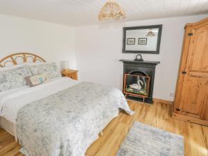 a bedroom with a bed and a fireplace at Mary Kate's Cottage in Narin