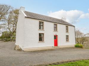 a white house with a red door at Mary Kate's Cottage in Narin