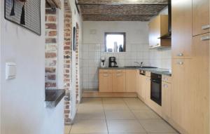 une cuisine avec des placards en bois et un mur en briques dans l'établissement Rozemeers, à Hollebeke