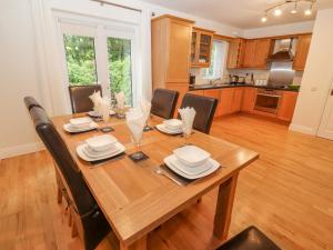 a dining room table with chairs and a kitchen at No 4 Lansdowne Village in Kenmare