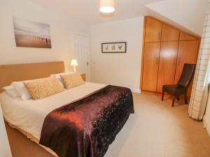 a bedroom with a large bed and a chair at No 4 Lansdowne Village in Kenmare