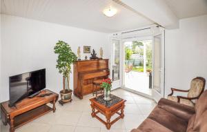 uma sala de estar com uma televisão de ecrã plano e um piano em Lovely Home In Argels-sur-mer With Kitchen em Argelès-sur-Mer