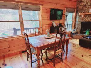 a dining room with a wooden table and chairs at LUXURY CABIN WITH WATERVIEW AND PRIVACY, hiking in Blue Ridge