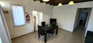 ein Esszimmer mit einem schwarzen Tisch und Stühlen in der Unterkunft DEPARTAMENTO CALAFATE CENTRICO #2 in El Calafate